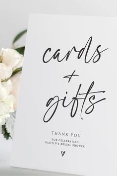 a white card with the words cards and gifts written on it next to some flowers