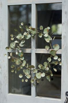 a close up of a metal plant on a window sill in front of a wooden wall