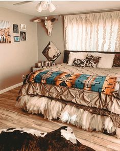 a bed sitting inside of a bedroom on top of a hard wood floor next to a window