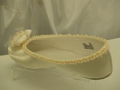 a pair of white shoes with pearls on them