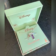 the disney necklace is in its box on the table