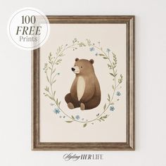 a brown bear sitting in front of a white wall with blue flowers and leaves around it