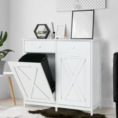 a white cabinet with some pictures on top of it and a rug in front of it