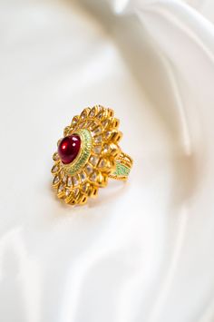 Pihu - Indian Modern Jewelry w/ Clear Kundan & Red Ruby Gemstone Stunning fine jewelry Kundan finger ring, made with hammered gold plated metal. Indian women's ring with red ruby stone sits at the centre, making this modern ring jewelry one of a kind. Beautiful design Kundans adorns this piece, adding grace. A stunning Meenakari outline enhances this piece making it perfect to be paired with any of your ethnic wear. Stone Setting: Kundan & Ruby Finish: Gold Plated Composition: Metal Alloy DELIVE Traditional Ruby Ring In Yellow Gold, Traditional Yellow Gold Ruby Ring, Gold Ruby Ring With 17 Jewels For Wedding, Traditional Gold Emerald Anniversary Ring, Traditional Hallmarked Ruby Ring, Elegant Ruby Ring For Festive Occasions, Traditional Oval Ring With 17 Jewels, Traditional Yellow Gold Ruby Ring With Gemstone, Traditional Oval Ruby Ring