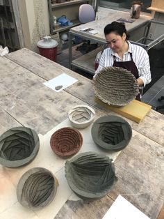 a woman is working on some pottery