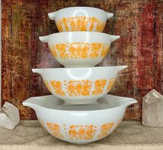 three orange and white bowls stacked on top of each other