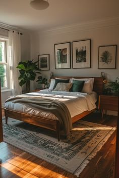 a bed sitting on top of a wooden floor next to two pictures hanging above it