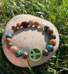 Green Peace Sign surrounded by Turquoise Siderolite, Jasper, Natural Agate, & Metallic Metal Beads.  Such an earthy 🌍 bracelet.  Made with super strong stretch elastic for easy on/off removal.  Can 🐝 worn alone or stacked.  Handmade with Love  💚☮️ Please note: Contains small parts, not recommended for children 0-3. Children over this age should be supervised if wearing. Hippie Green Bracelet Jewelry, Earthy Turquoise Bracelets For Festival, Handmade Hippie Bracelets For Meditation, Hippie Turquoise Round Bead Bracelets, Turquoise Hippie Bracelets As Gift, Turquoise Hippie Bracelets For Gifts, Green Natural Stone Festival Bracelets, Hippie Healing Bracelets With Round Beads, Bohemian Stretch Bracelet For Friendship