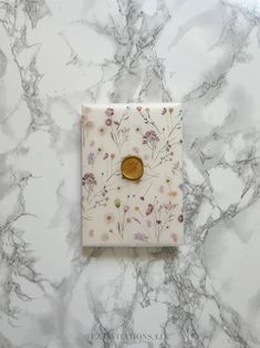 a white marble wall with a gold button on it's side and flowers all over the surface