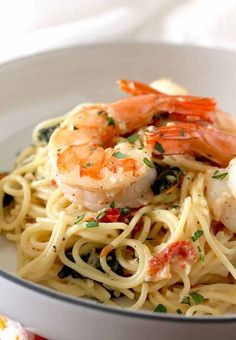 pasta with shrimp and spinach in a white bowl