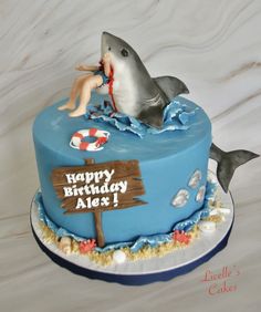 a blue birthday cake with a dolphin on top