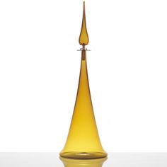 a tall yellow glass vase sitting on top of a table