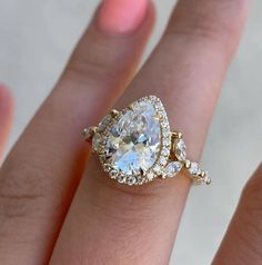 a woman's hand with a diamond and gold ring on top of her finger