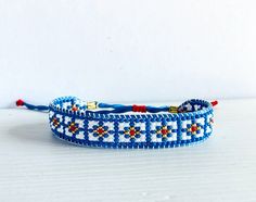 a blue and white beaded bracelet sitting on top of a table