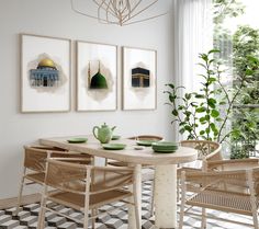 a dining room table with chairs and pictures on the wall above it, in front of a potted plant