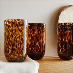 three brown glass cups sitting on top of a wooden table