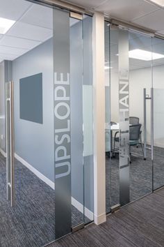 an office cubicle with glass walls and doors that say upstope on it