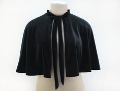 "Black velvet capelet with neck tie. The velvet or velour has a stretch so drapes very nicely, it is lined with a red tartan fabric and fastens at the neckline with a tie. It measures approx 16\" from the neckline down to the hem. I am making this cape to order, so if you would like a different colour lining, contact me before ordering and I can check what I have available." Fitted Fall Cape For Evening Wear, Chic Fitted Capelet For Formal Occasions, Black Fitted Cape For Formal Occasions, Elegant Fitted Winter Capelet, Formal Black Capelet, Fitted Black Formal Cape, Formal Fitted Winter Cape, Formal Fitted Black Cape, Winter Formal Fitted Cape