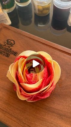 a paper flower sitting on top of a wooden cutting board