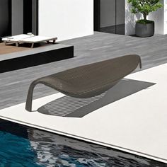 an outdoor lounge chair sitting on top of a swimming pool