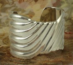 "Nice Mexican sterling swirl cuff bracelet. Marked 950 (925 is sterling, this is a higher purity of silver than sterling). It is signed Alicia. It has LLP XMAS '86 scratched into the interior. Alicia is a retailer. I think this is their site: http://www.aliciaplata.com/en/quienes.html Significant surface scratching from regular wear. The interior diameter of this cuff bracelet measures 2 inches wide. The band: At its widest point it is 1 3/4 inches wide. It weighs 72.4 grams." Silver Spiral Cuff Bracelet Gift, Vintage Silver Cuff Bangle, Elegant Silver Spiral Cuff Bracelet, Elegant Silver Spiral Bangle, Nickel-free Vintage Cuff Jewelry, Luxury Silver Modernist Cuff Bracelet, Vintage Nickel-free Sterling Silver Cuff Bracelet, Long Rope, Adjustable Sterling Silver Cuff Bracelet, Modernist Style