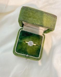 an engagement ring in a green velvet box