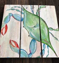 three pieces of wood painted with blue, green and red flowers on them sitting on a wooden floor