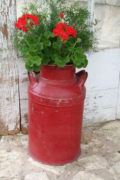 a red vase with some flowers in it