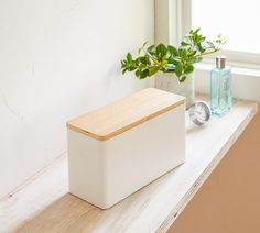 a white box sitting on top of a counter next to a window