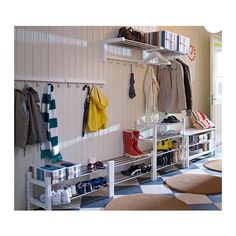 a white coat rack filled with coats and shoes next to a checkered floor in a room