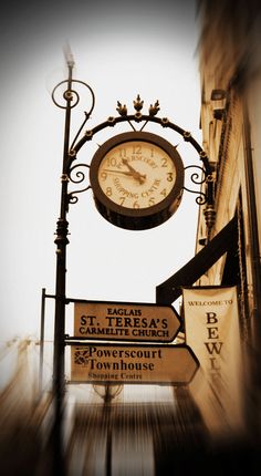 a street sign with a clock attached to it