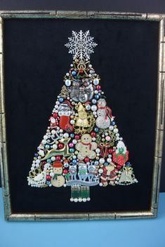 a christmas tree made out of buttons and other items on a black background with silver frame