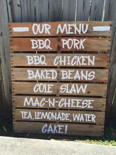 a wooden sign that says our menu for barbecue pork, bbq chicken, baked beans, cole slaw and mac n cheese tea lemonade water cake