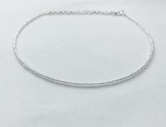 This dainty clear beaded necklace is made with glass seed beads.  It is a perfect necklace for layering or to wear on its own! The necklace is approximately 14 inches long with 3 inches of extender chain, making it easily adjustable.  Looking for a simple necklace that goes with every outfit? Look no further! This beautiful clear necklace makes a great gift or purchase for yourself! Transparent Beads Necklace, Crystal Necklaces With Delicate Chain And Round Beads, Dainty Faceted Bead Choker Necklace, Dainty Crystal Necklaces With Tiny Beads, Silver Faceted Beads Choker, Adjustable Silver Beaded Necklace With Delicate Chain, Silver Single Strand Choker With Round Beads, Silver Choker With Faceted Beads For Gift, Dainty Adjustable Choker With Faceted Beads