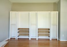 an empty room with white closets and wood floors