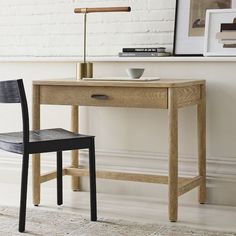 a wooden desk with a black chair next to it