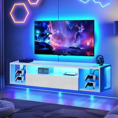 a living room with a large television and video game controllers on the entertainment center wall