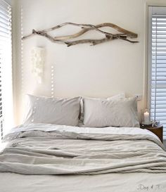 a bed with white sheets and pillows in a bedroom