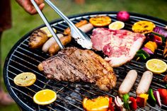 a person is grilling meat and vegetables on a bbq with two tongs