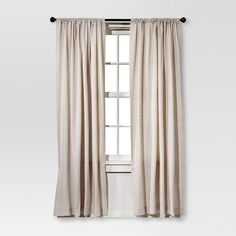 a white curtain hanging on the side of a window in front of a white wall