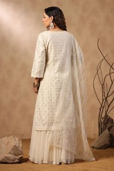 White silk kurta with floral jaal pattern embroidery. Comes with sharara and embroidered dupatta.
Components: 3
Pattern: Embroidered
Type Of Work: Floral Jaal, Sequins, Pearls, Cutdana
Neckline: U Neck
Sleeve Type: Three Quarter
Fabric: Kurta: Silk, Sharara: Georgette, Dupatta: Organza
Color: White
Other Details: 
Attached lining
Approximate product weight: 0.5-1 kg
Occasion: Sangeet - Aza Fashions Off White Silk Anarkali Set With Dupatta, Chanderi Palazzo Set With Resham Embroidery For Diwali, Chanderi Sharara For Reception During Eid, Raw Silk Off-white Sets For Festivals, Off White Raw Silk Set For Festivals, Off White Sets With Zari Work For Transitional Season, Bollywood Style Off White Raw Silk Set, Off White Bollywood Raw Silk Set, Unstitched Chinon Suit With Cutdana For Eid