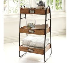 three tiered storage rack with towels and other items in front of a large window