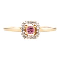 a yellow gold ring with a pink sapphire and white diamonds in the center, on a white background