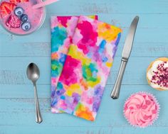 colorful napkins and cupcakes on blue wooden table