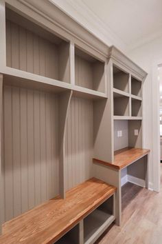 a wooden bench sitting in the middle of a room next to a book shelf and door