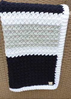 a black and white crocheted dishcloth hanging on a wall