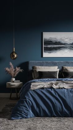 a bed with blue sheets and pillows in a room painted teal, grey and white