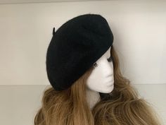 a mannequin's head wearing a black hat with horns on it and long blonde hair