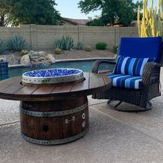 a patio with a table, chair and pool in the backround next to it