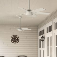 a porch with two wicker chairs and a clock on the wall